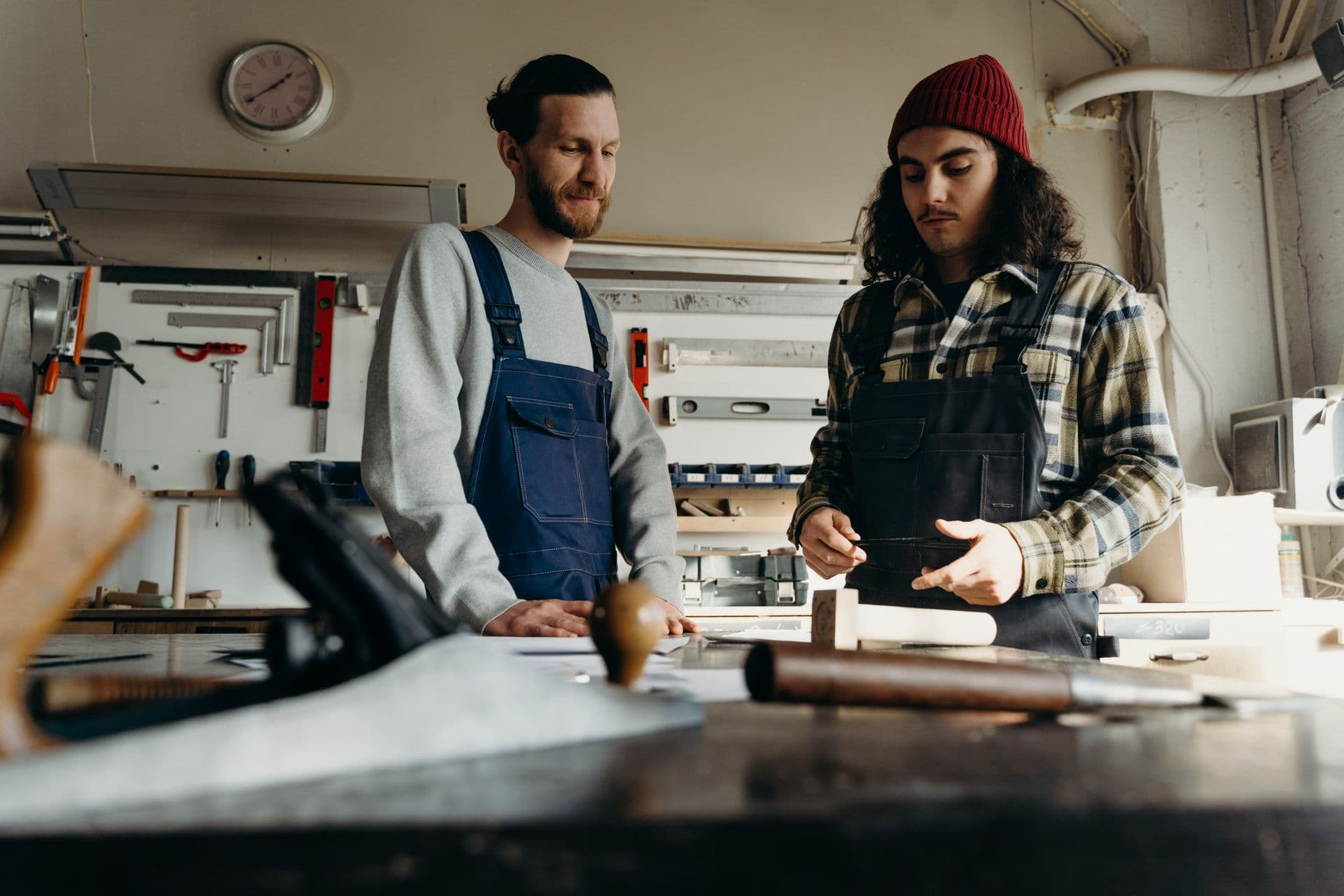 Zwei Handwerker besprechen sich in einer hellen Werkstatt